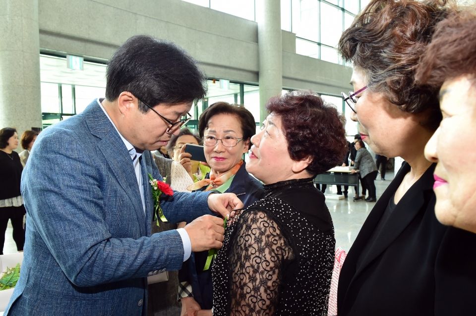 자료사진_지난 5월 어버이날 기념행사에서 염태영 수원시장이 어르신에게 카네이션을 달아주고 있다.